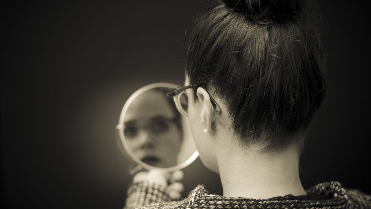 Glaube an dich selbst - Selbstwirksamkeit Frau sieht in ihr Spiegelbild